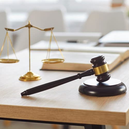 Mazo y balanza sobre la mesa del despacho de Giráldez y Garrido Abogados en Caldas de Reis